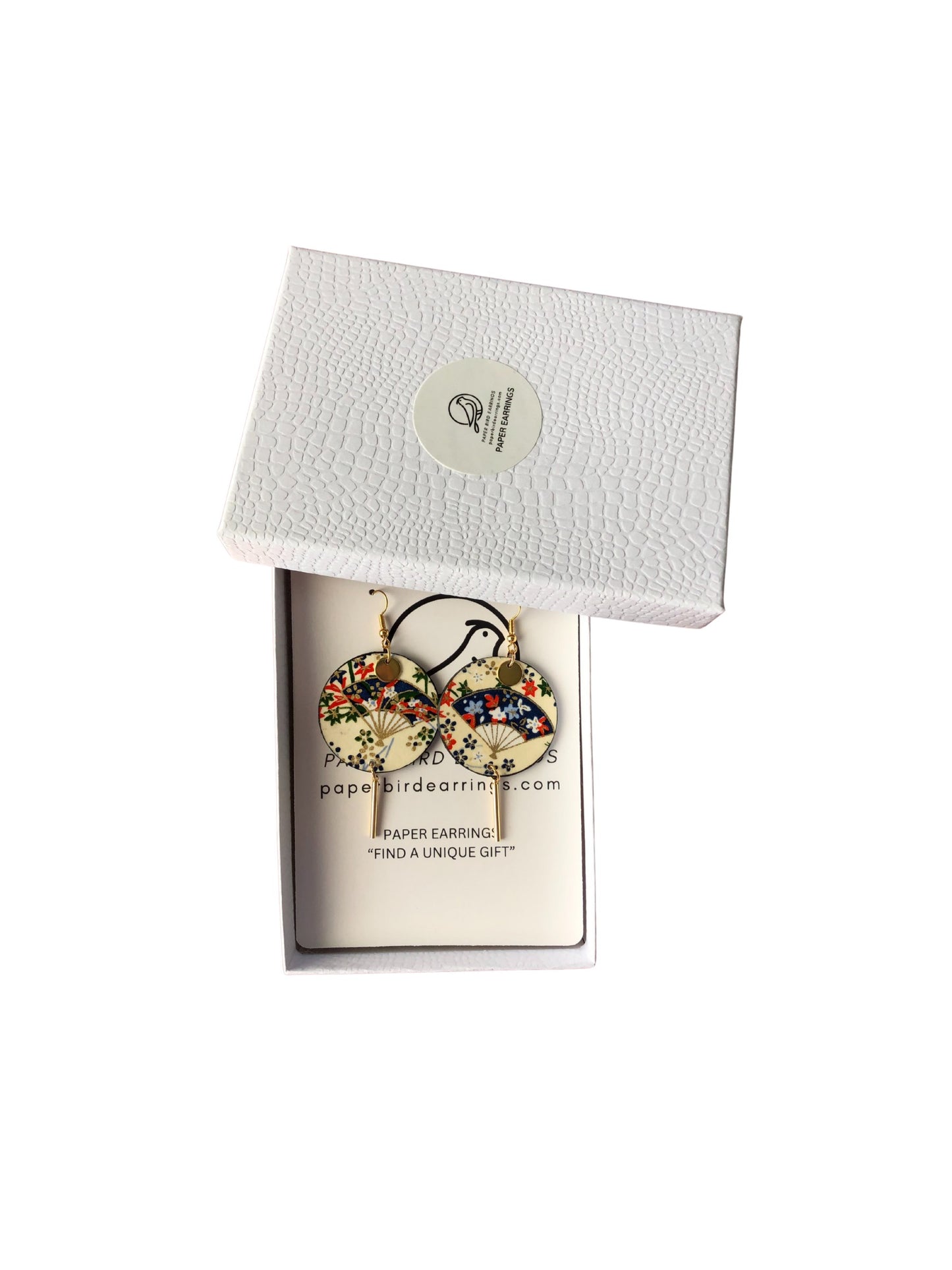 Earring in a white box with a visible brand label on a white background