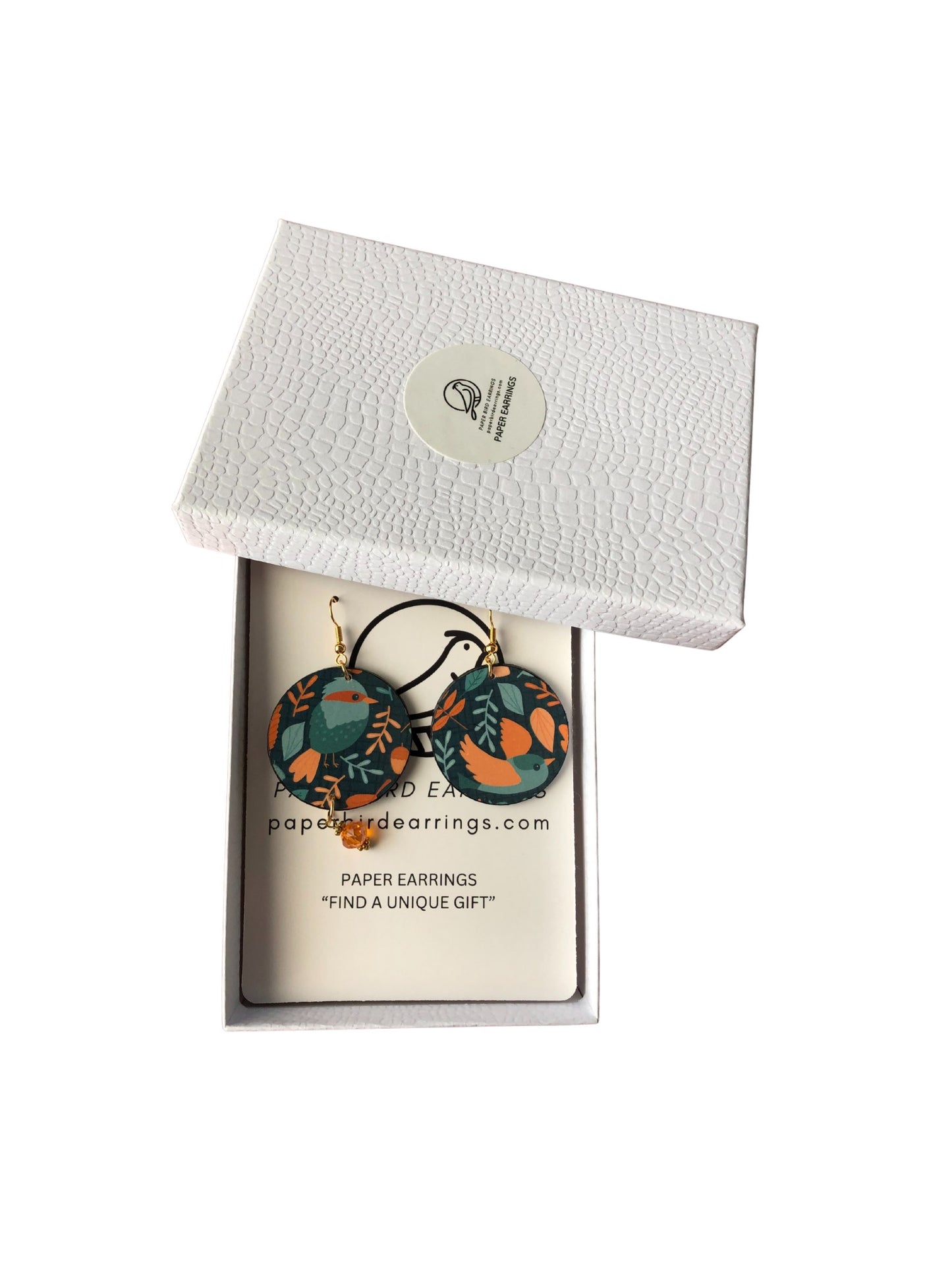 Decorative earrings in a white box with a visible brand label.