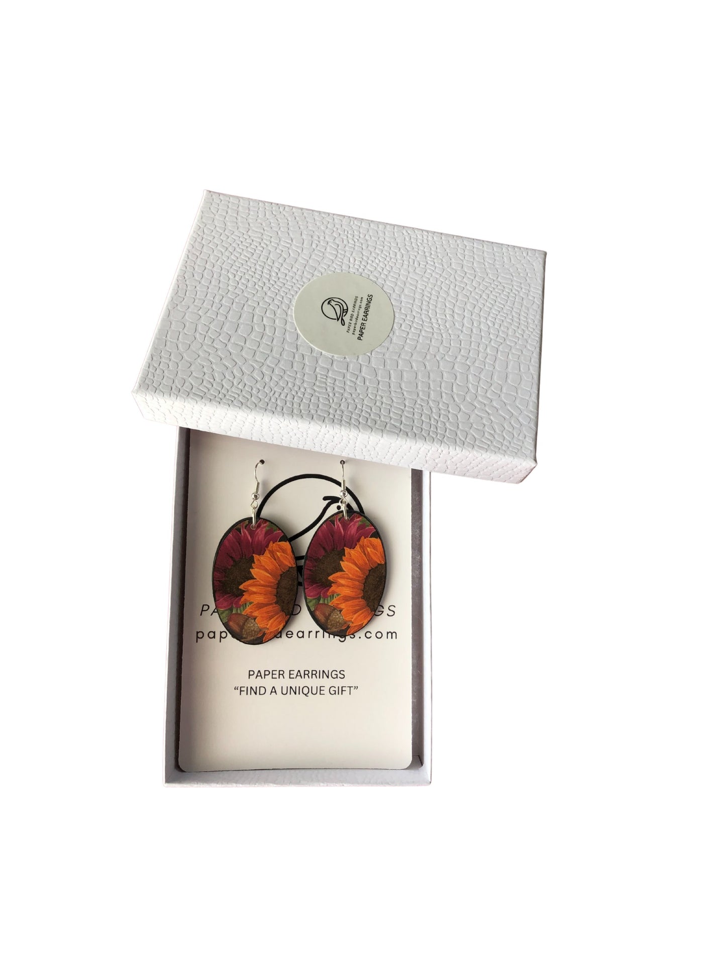 Sunflower-patterned earrings in a white box with a brand label.