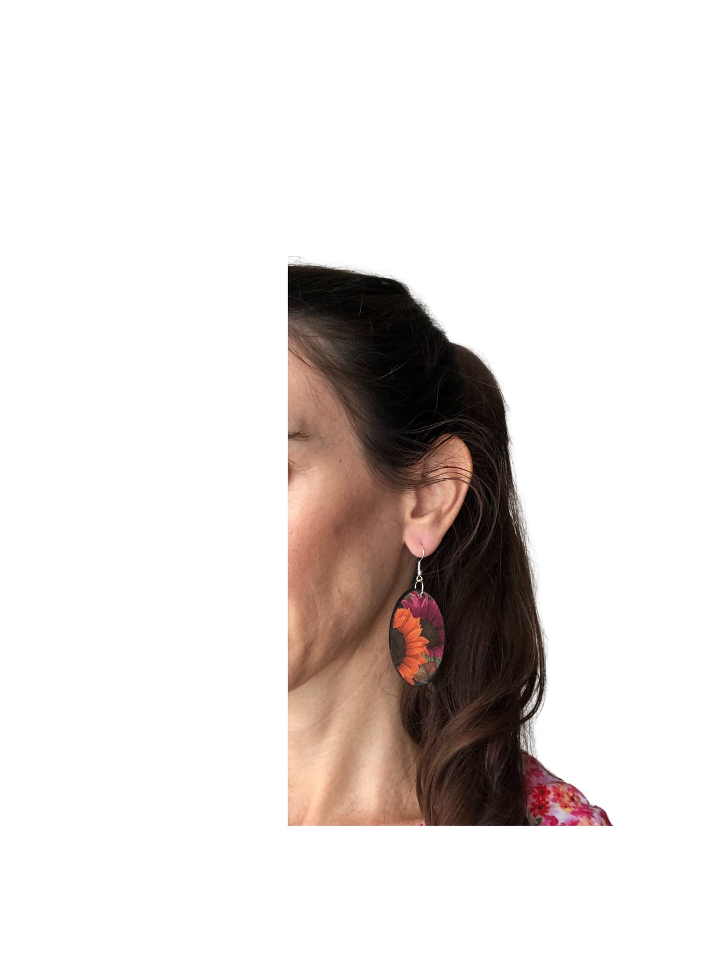 Close-up of a person wearing colorful earrings with a white background