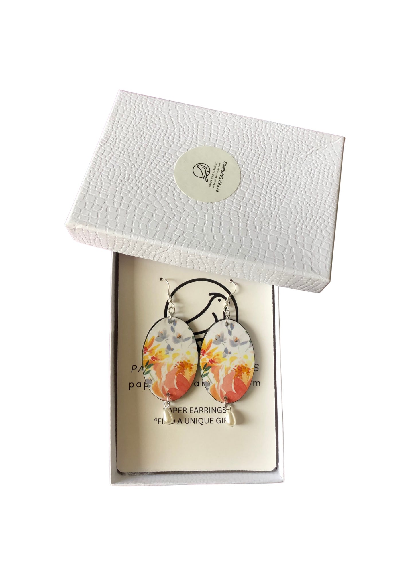 Floral earrings in a white box with a visible brand label.