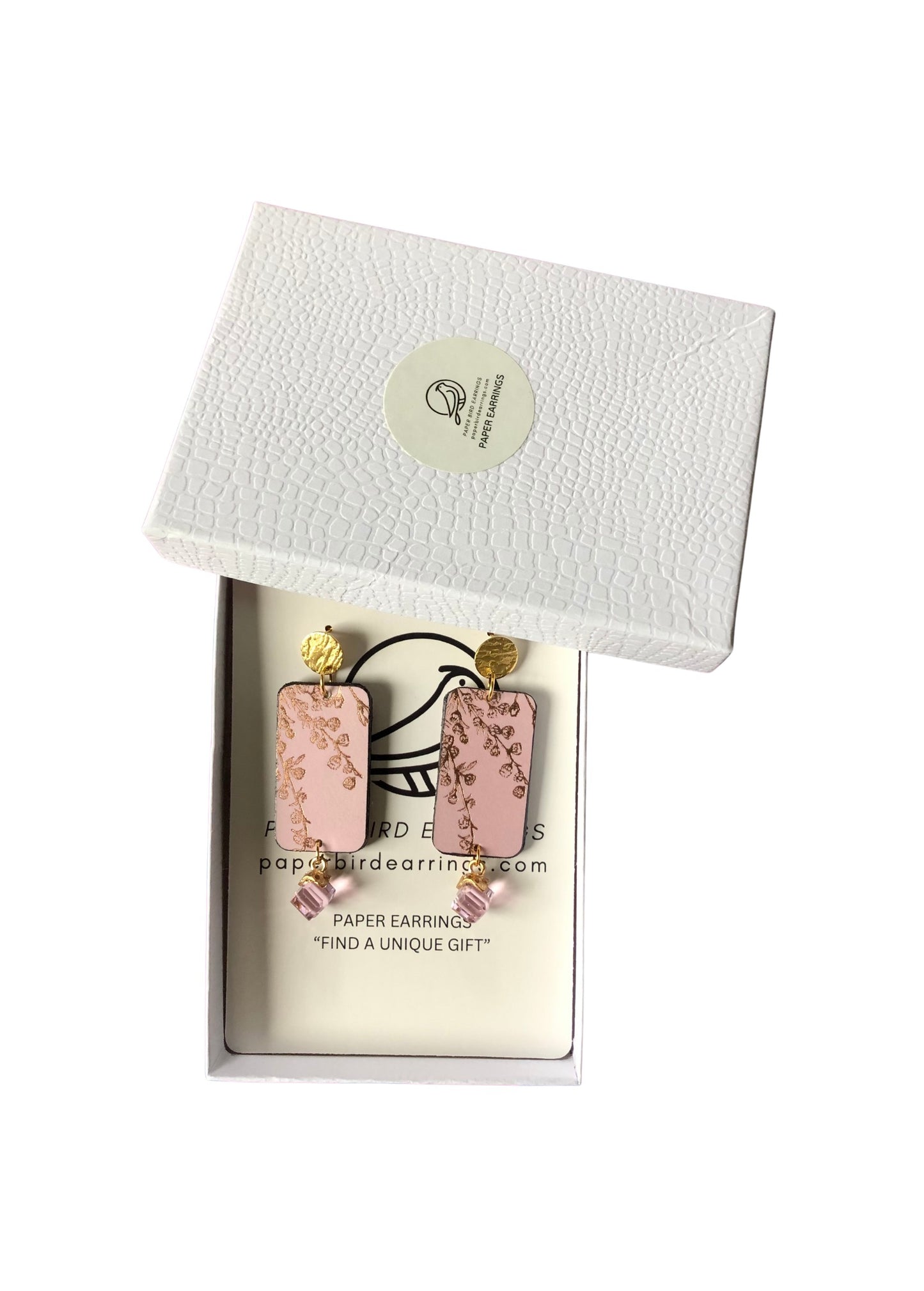 Pink floral earrings in a white box with a brand logo on a white background