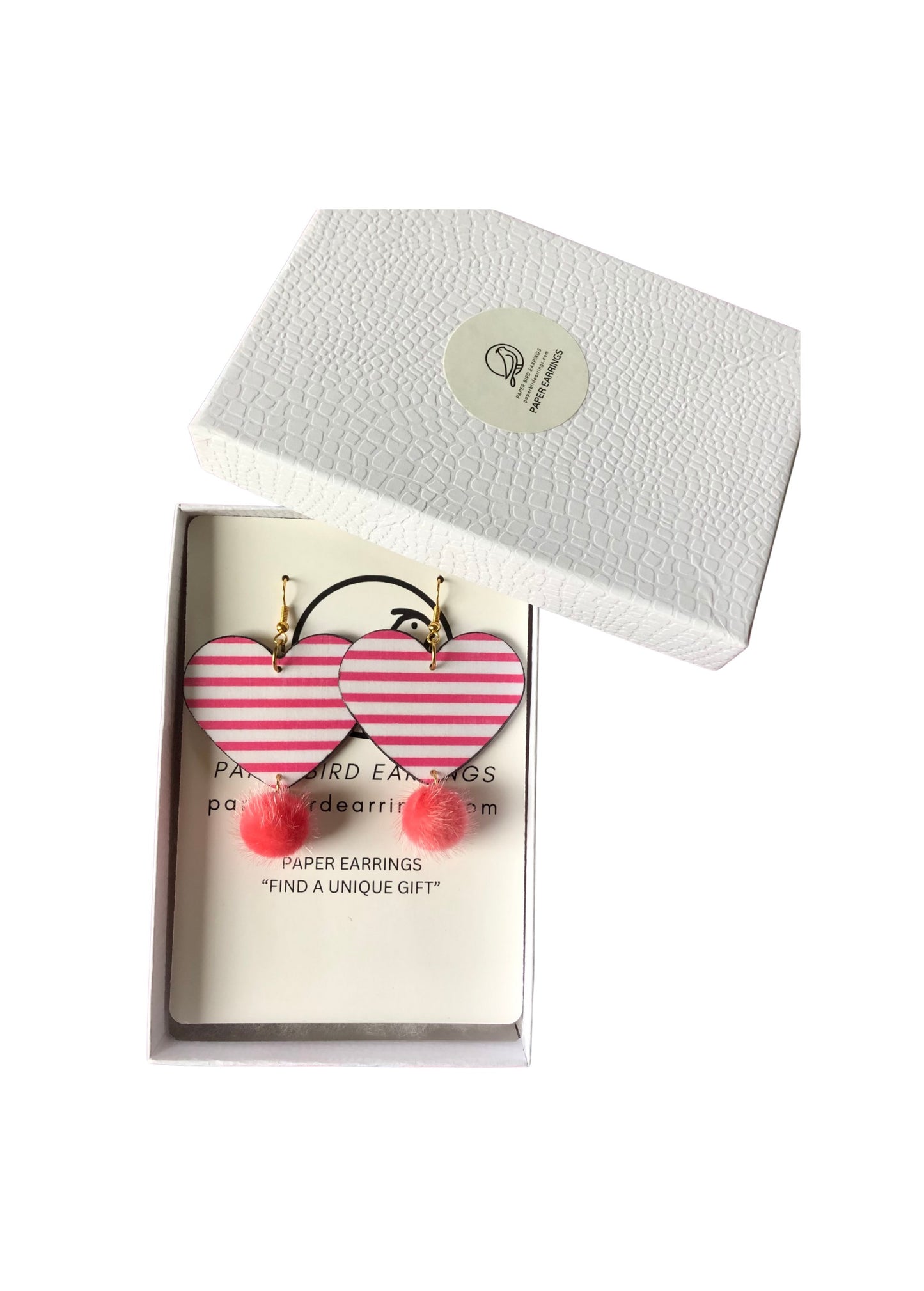 Heart-shaped pink and red earrings in a box with a white background