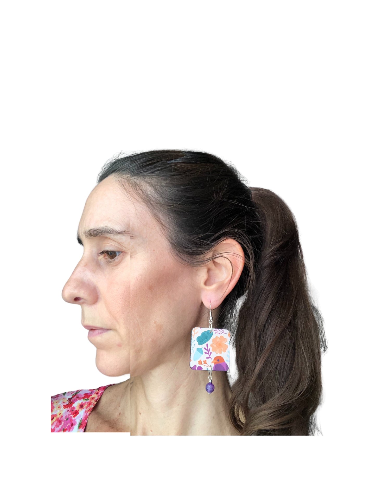 Woman wearing colorful earrings with a white background