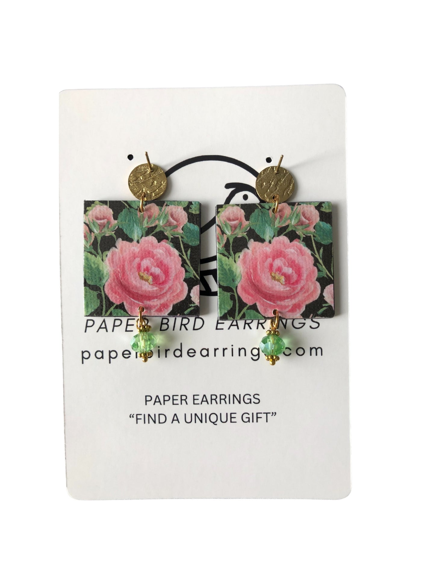 Floral paper bird earrings on a white card with branding information.