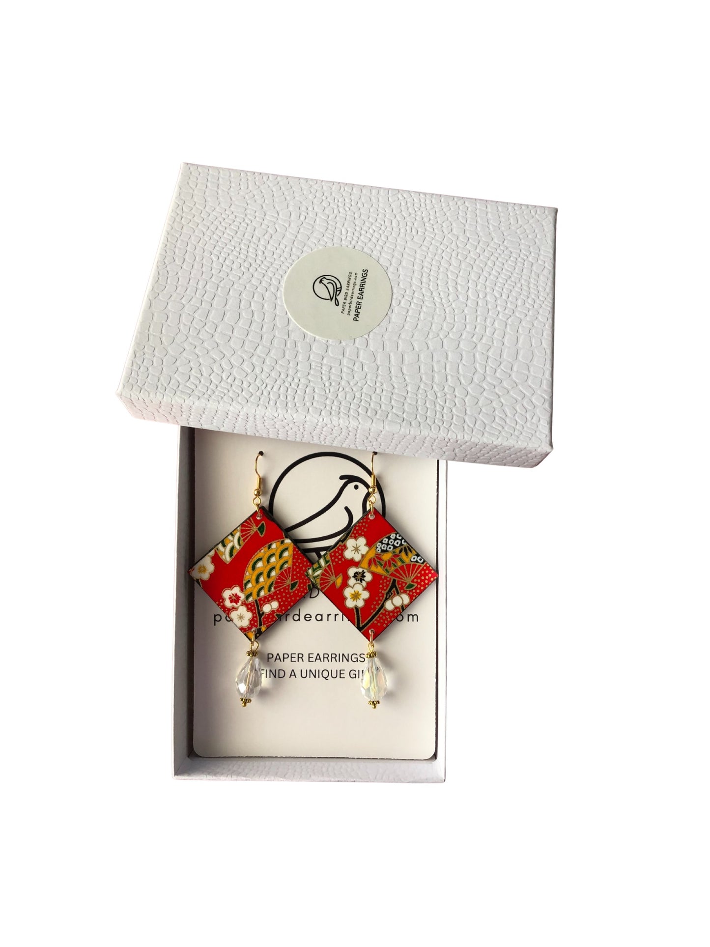 Red floral earrings in a white box with a brand label.