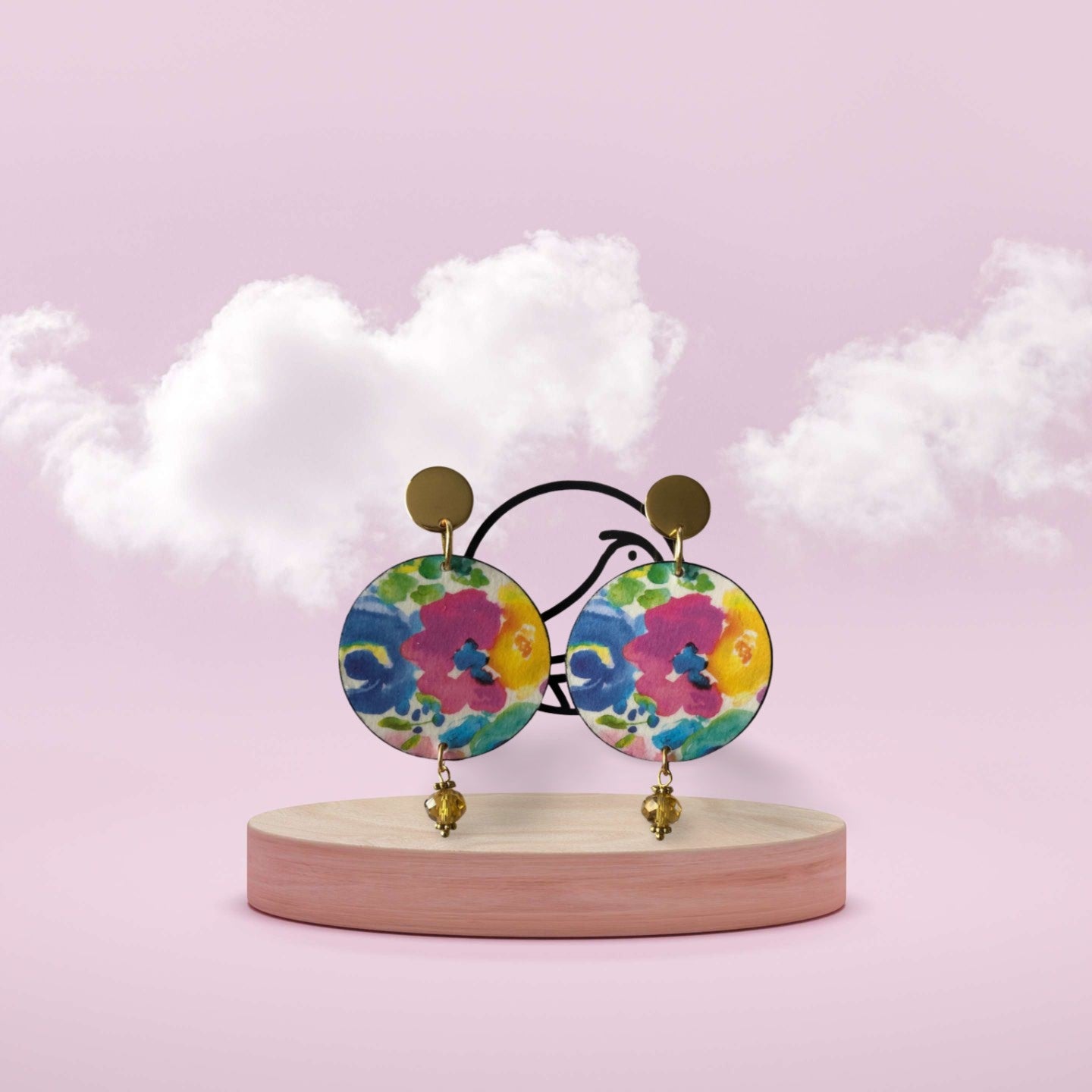 Colorful floral earrings on a wooden stand with a soft pink background