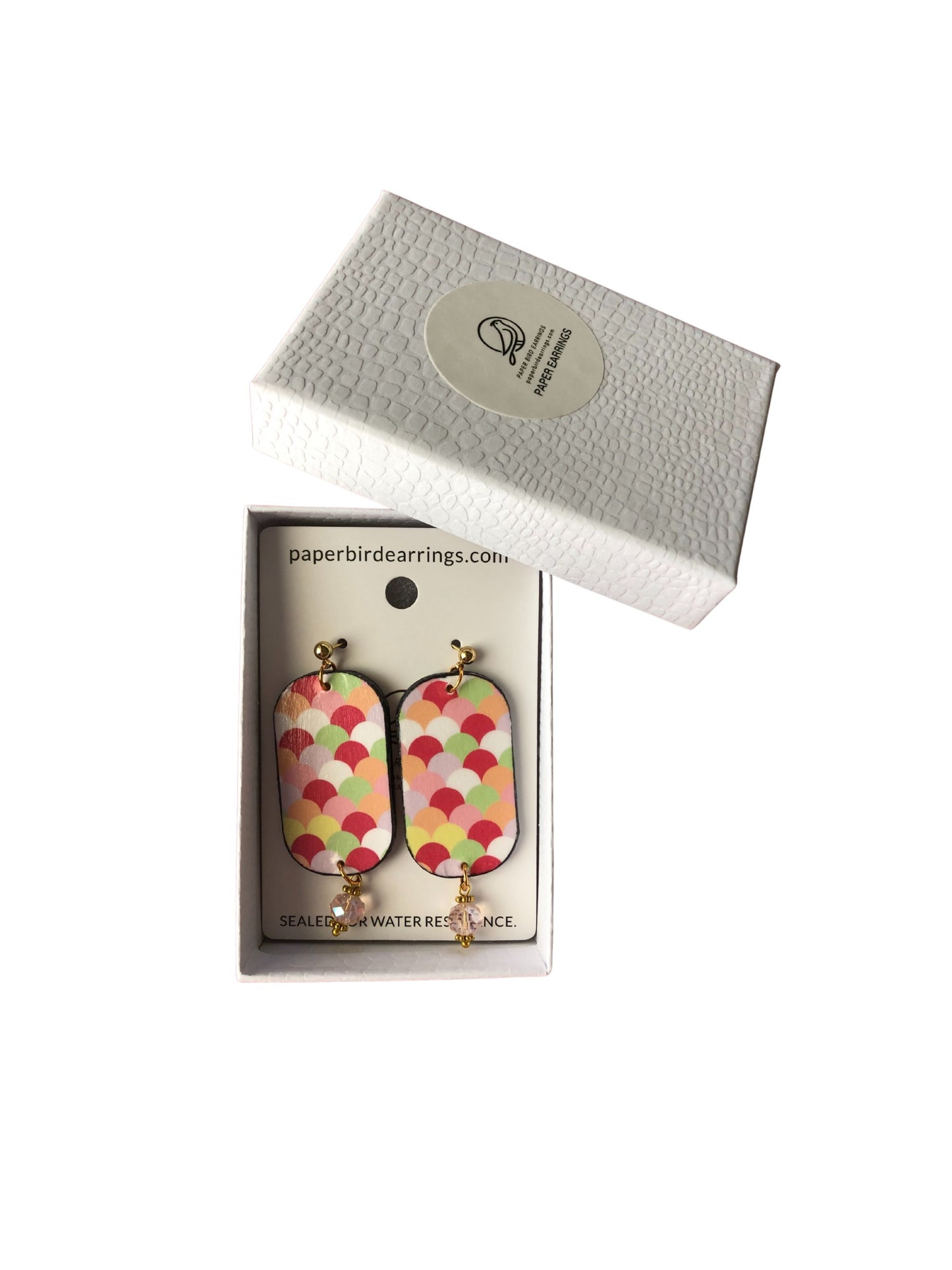 Colorful scale-patterned earrings in a branded box on a white background