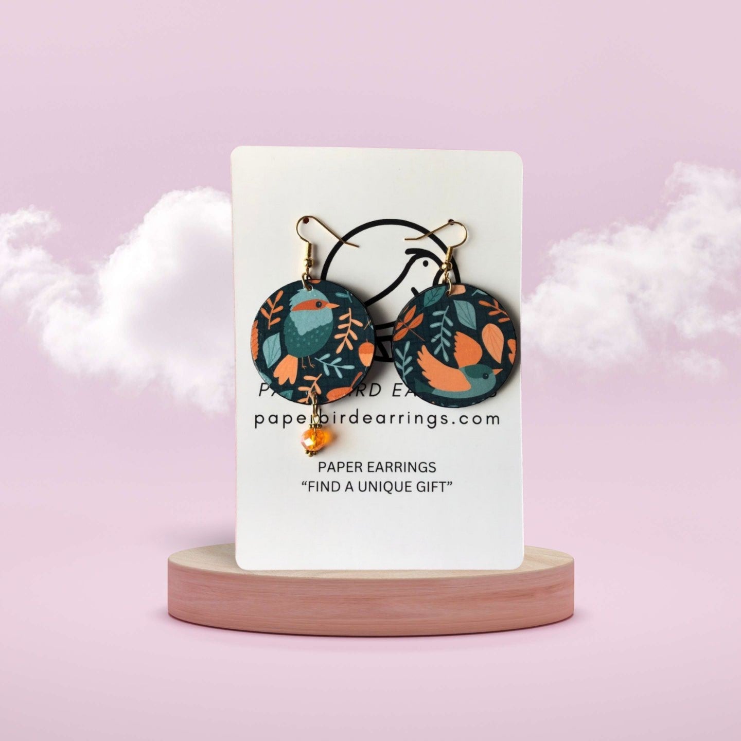 Pair of floral-patterned earrings on a white card with 'paperbirdearrings.com' text, against a light pink background.