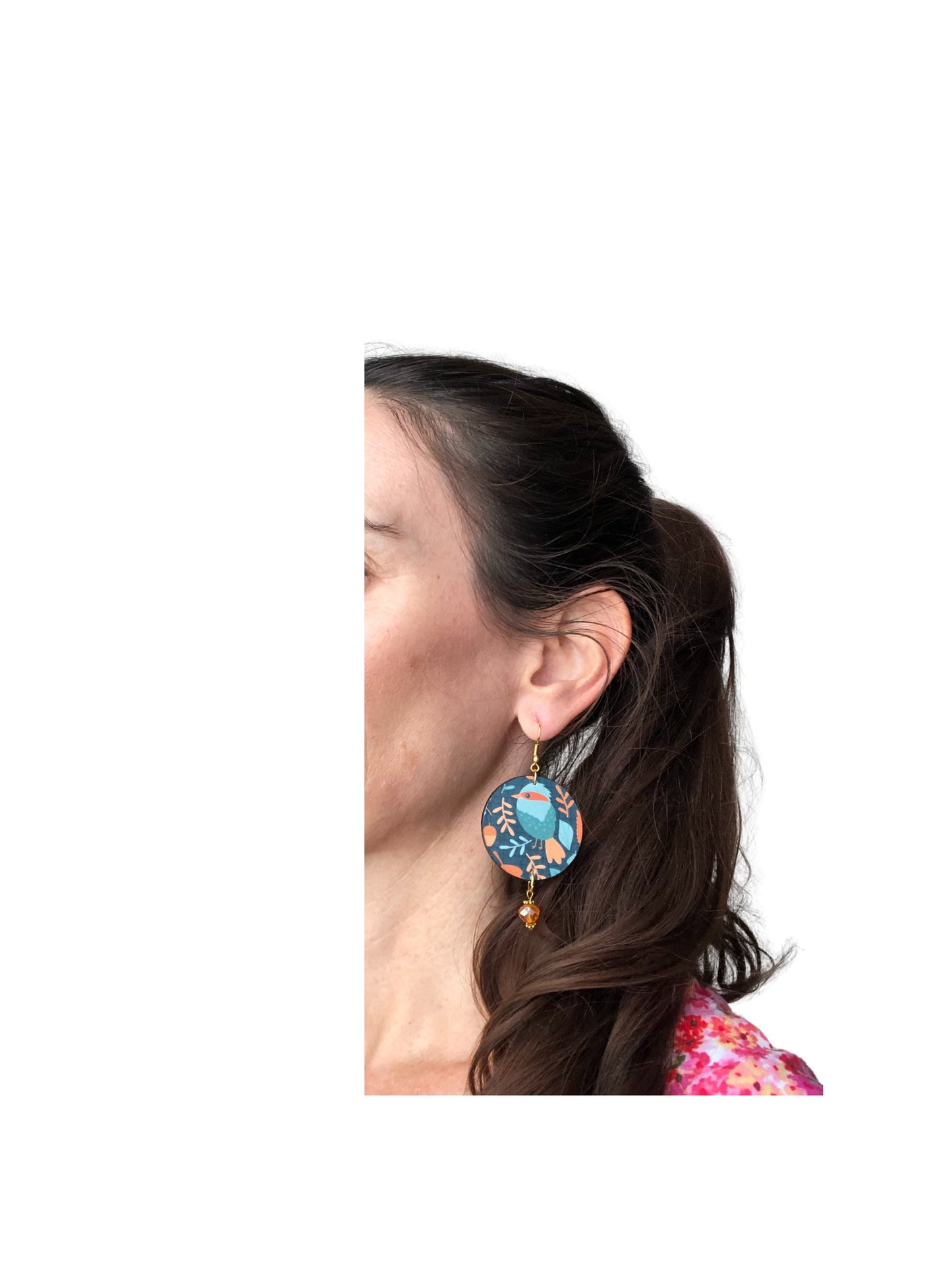 Close-up of a person wearing a colorful earring with a white background