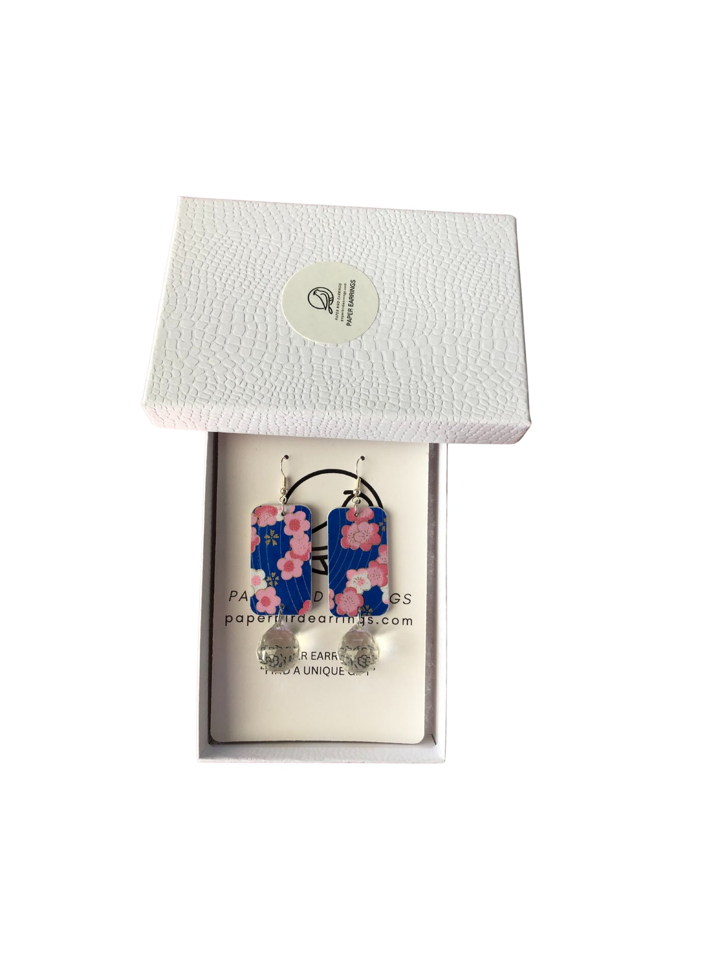 Floral earrings in a white box with a visible brand logo.