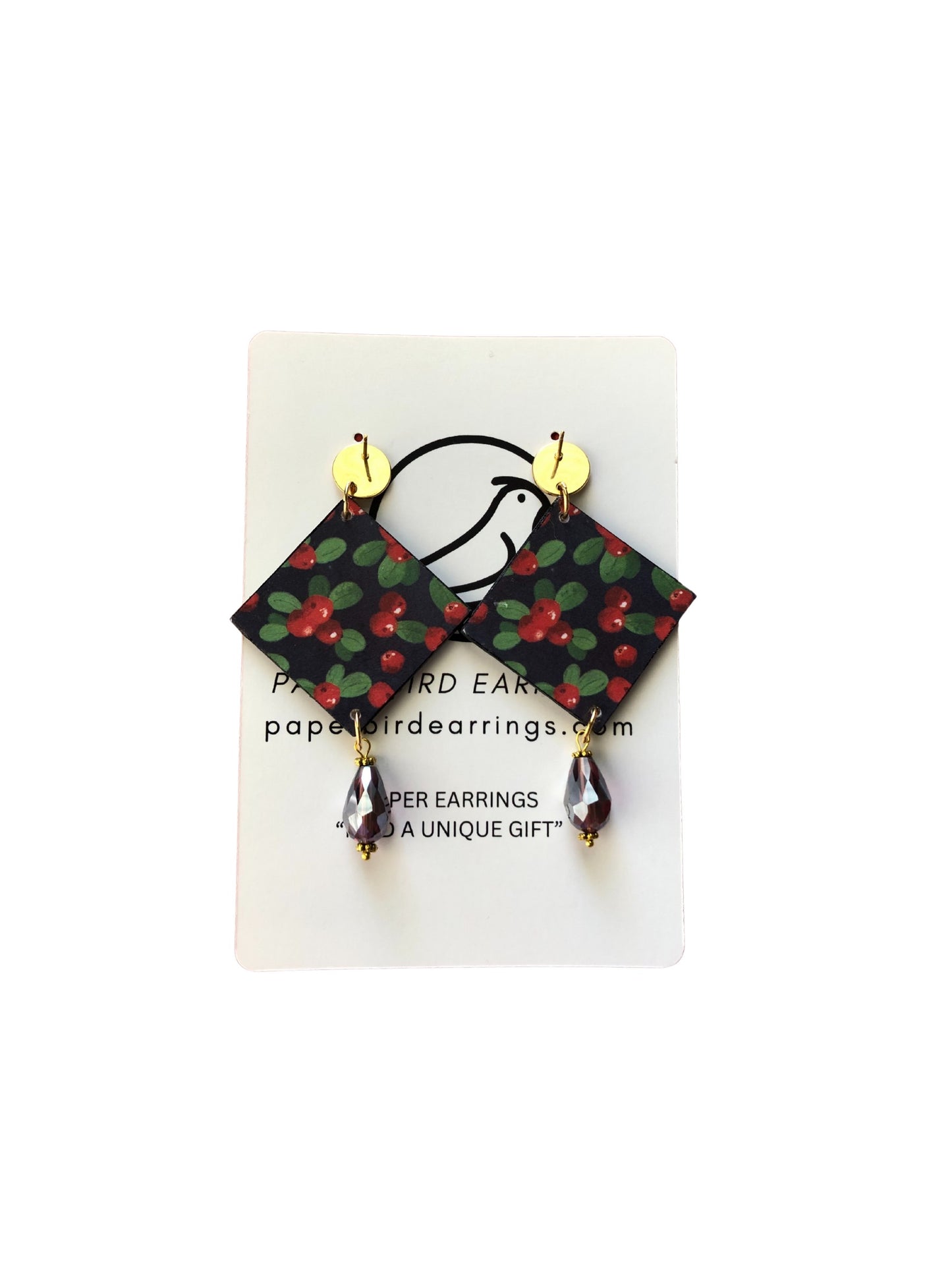 Pair of paper bird earrings on a white card with branding information.