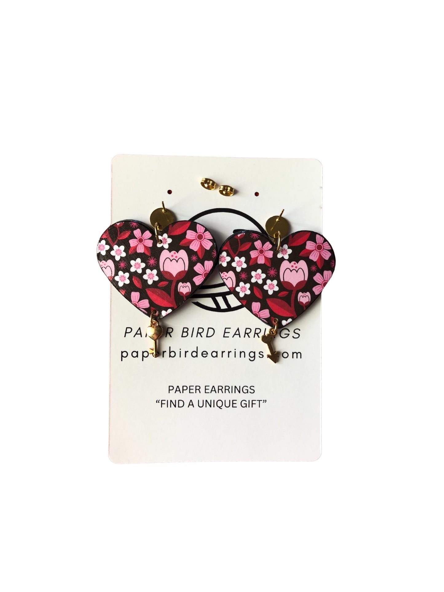 Heart-shaped paper bird earrings on a display card with branding information.