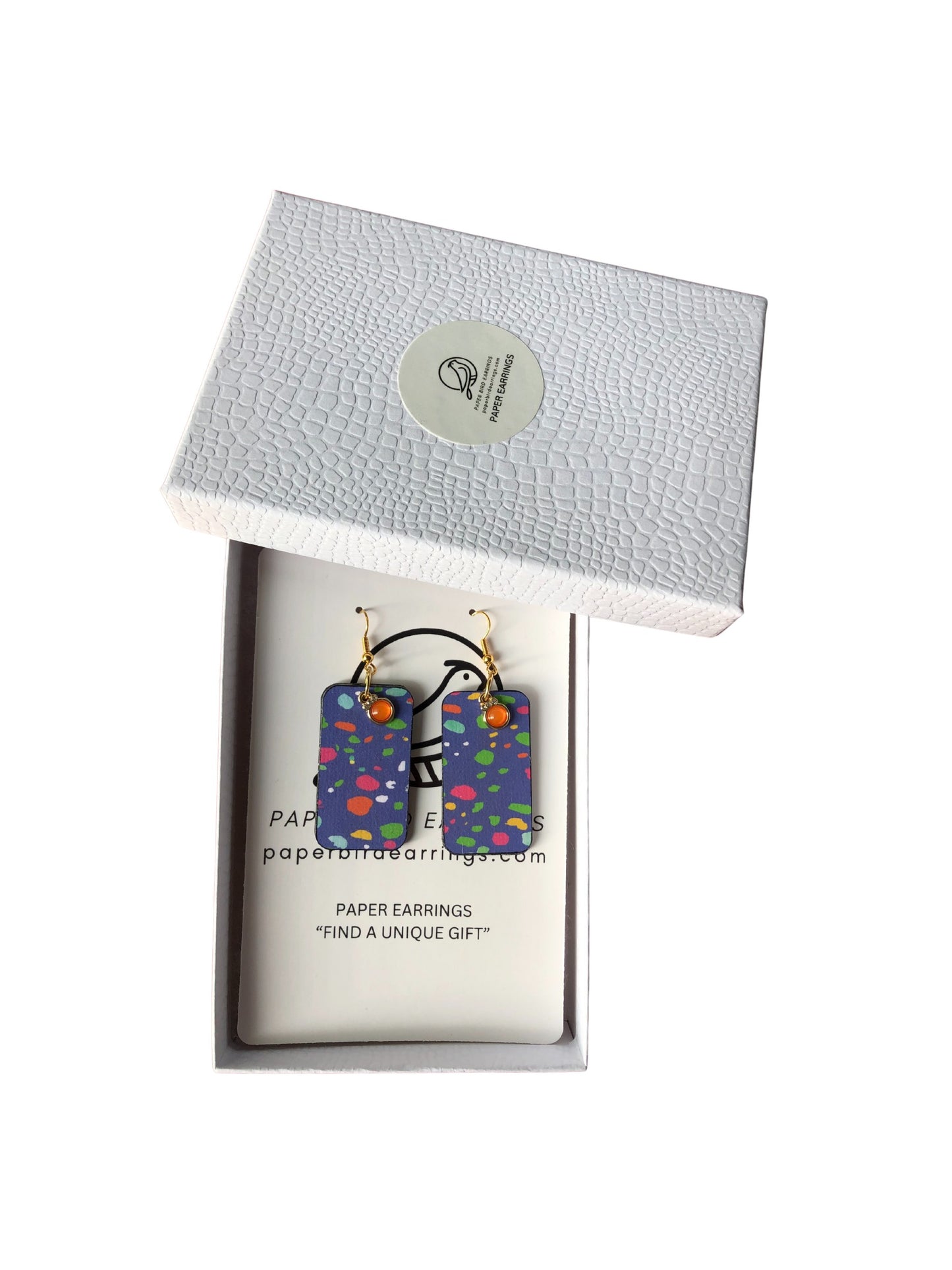 Colorful earrings in a branded box on a white background
