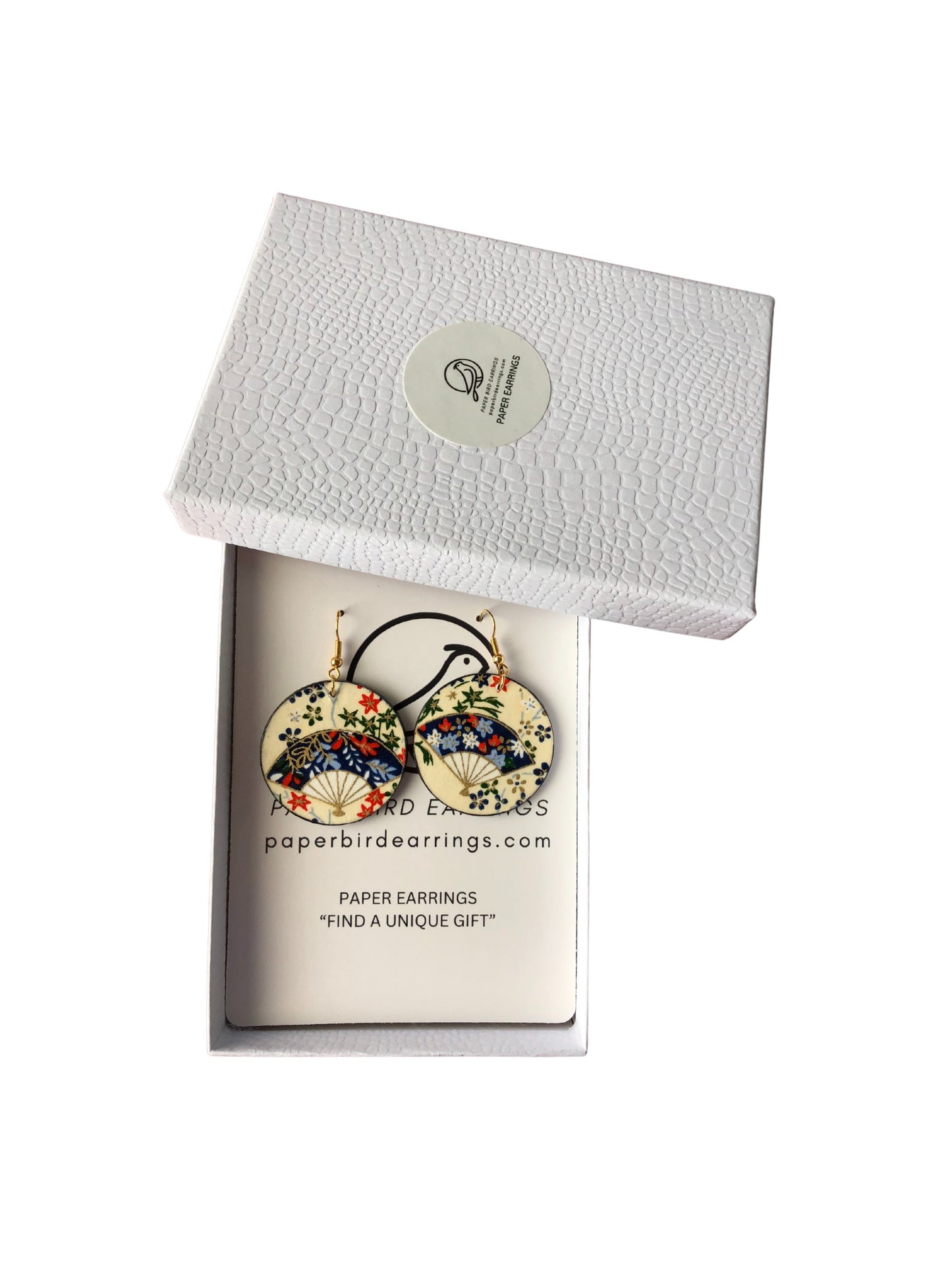 Decorative earrings in a branded box on a white background