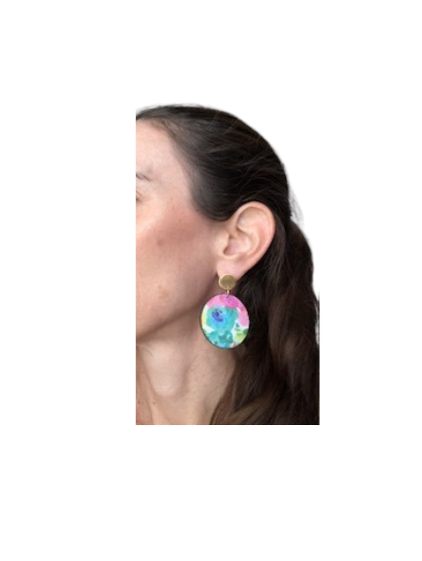 Close-up of a person wearing colorful earrings on a white background