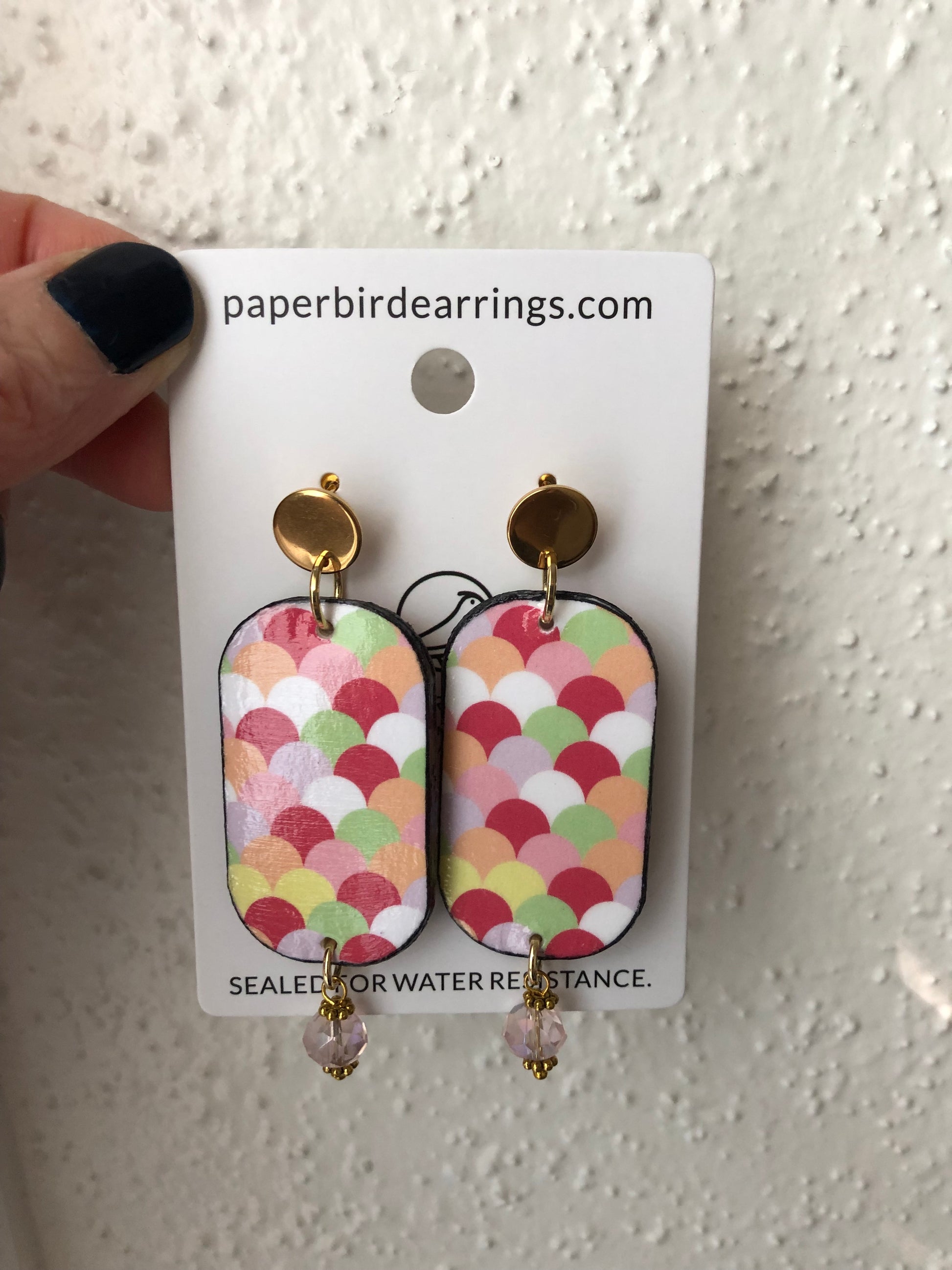 handmade paper earrings with a colorful art deco design on pink, red, green, white and orange