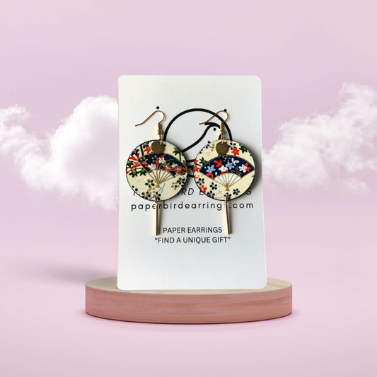 Pair of paper earrings on a white card with a pink background