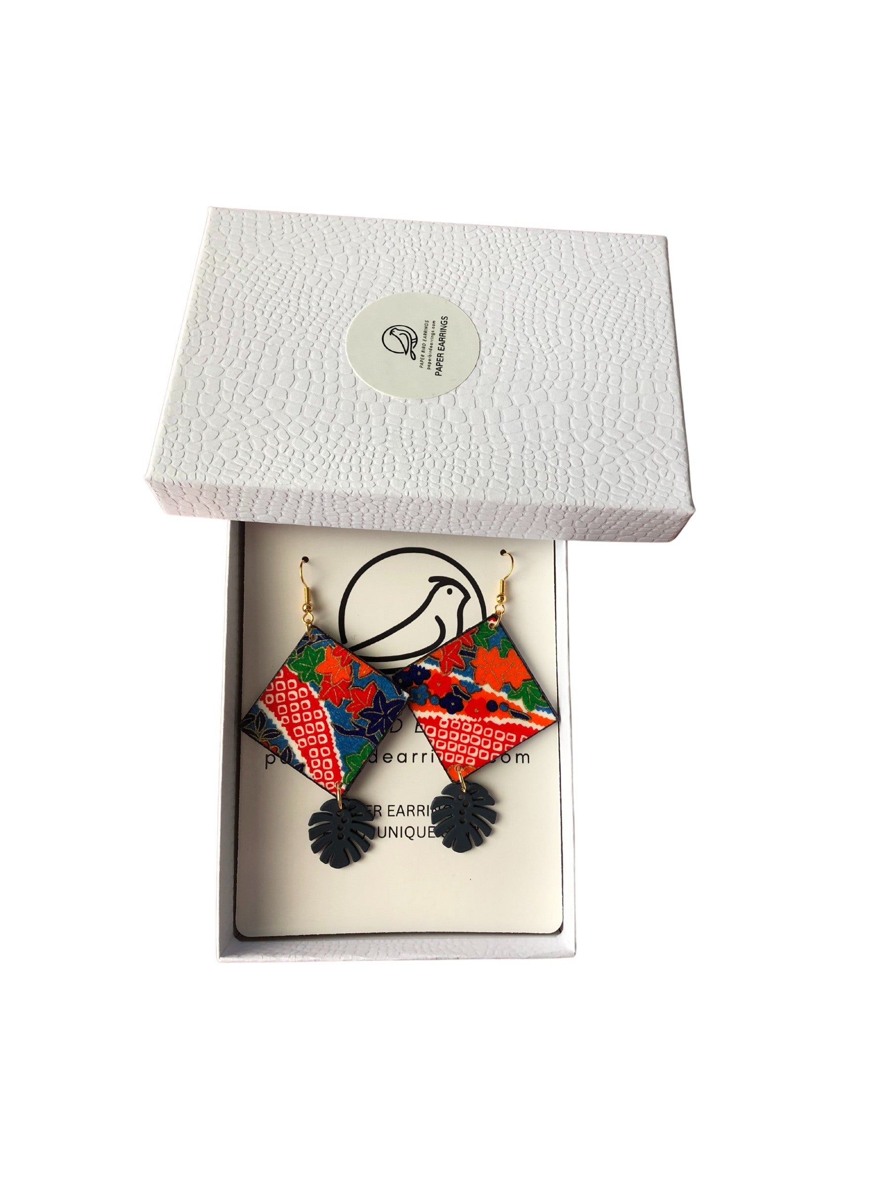 Colorful earrings in a white box with a visible brand logo.