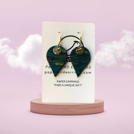 Heart-shaped paper earrings on a display card with a pink background