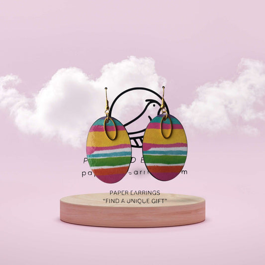 Colorful striped earrings on a wooden stand with a pink background