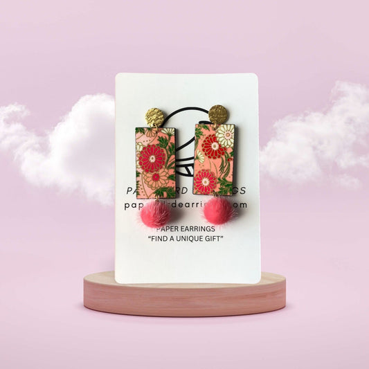 Floral paper earrings on a white card with a pink background