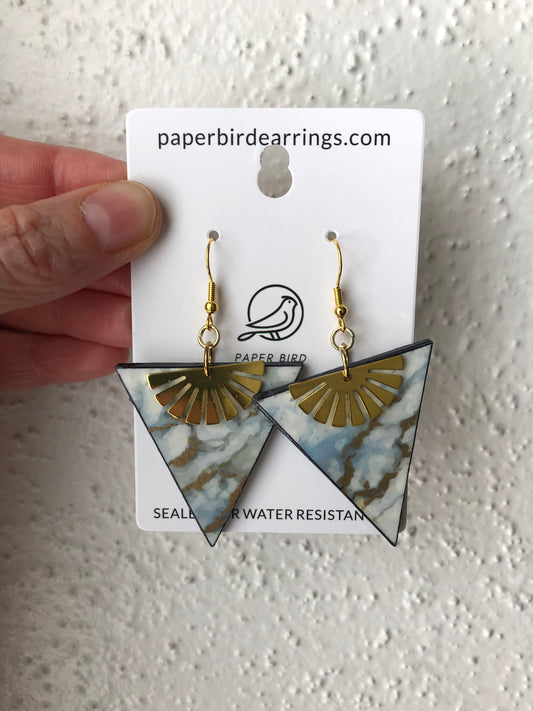 Triangle-shaped earrings on stone marble paper