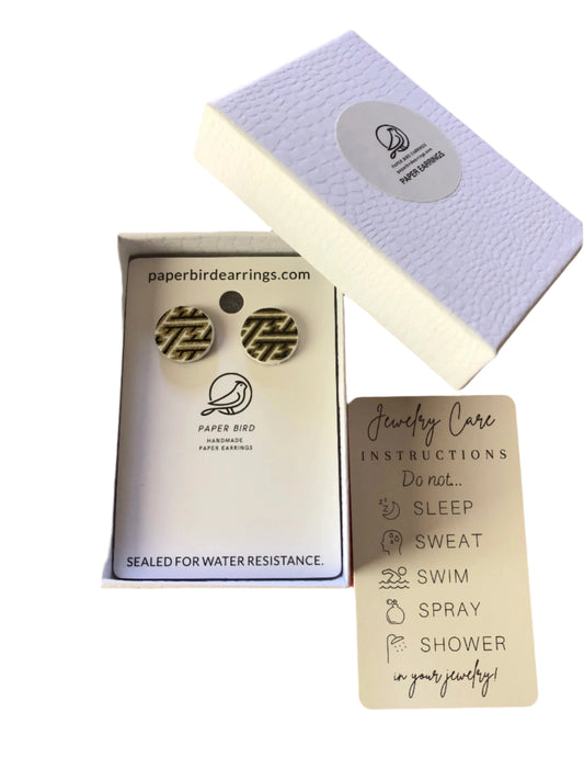Earring box with earrings inside, jewelry care card, and brand logo on a white background