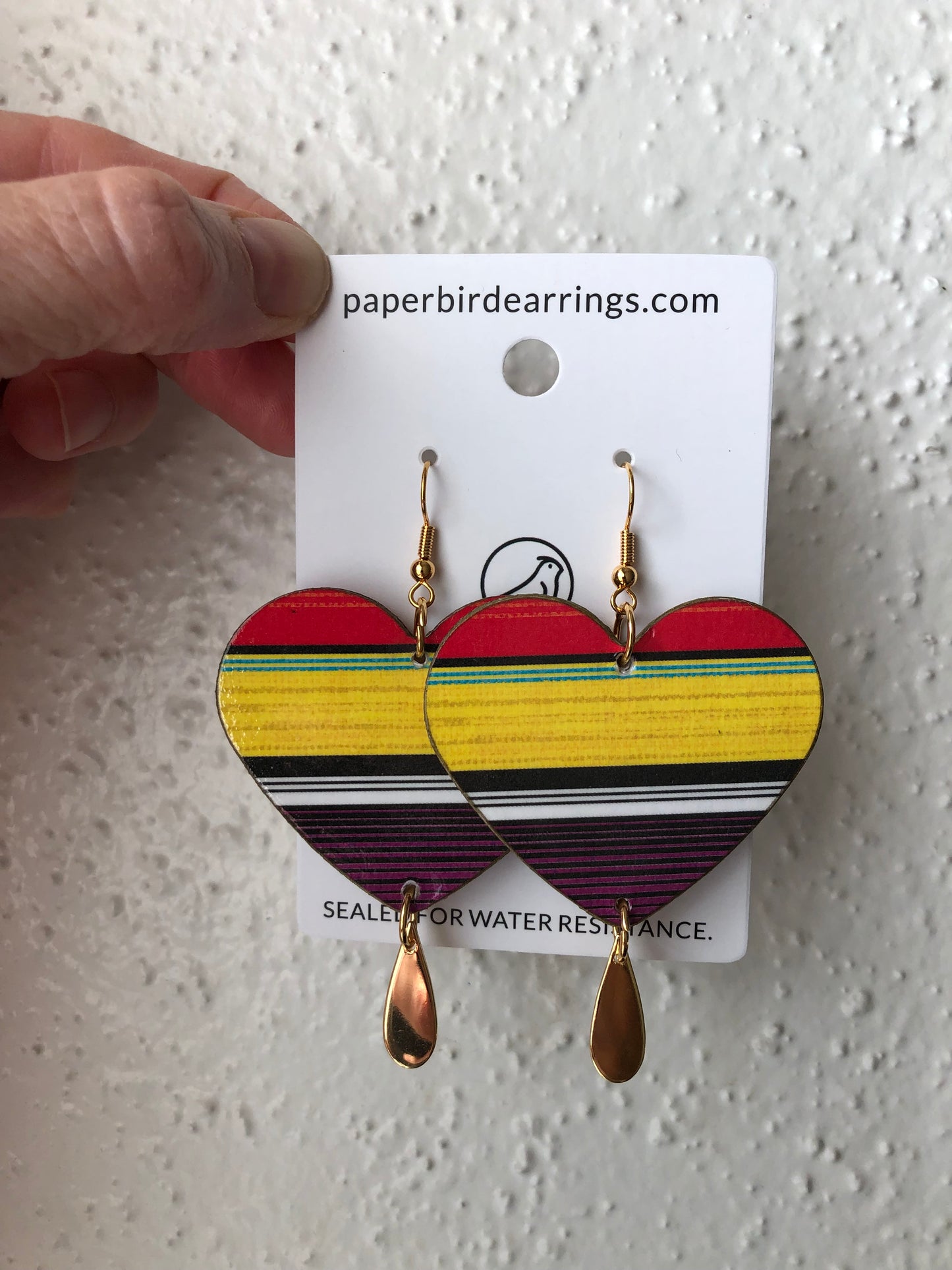 Heart-shaped paper earrings with colorful striped design 