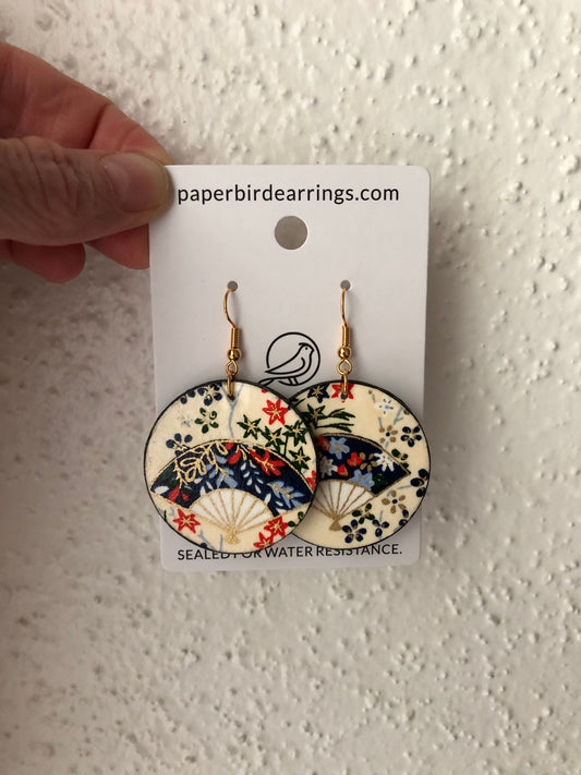 round shaped paper earrings with a sensu or Japanese folding fan of blue color on a beige background handmade paper bird earring