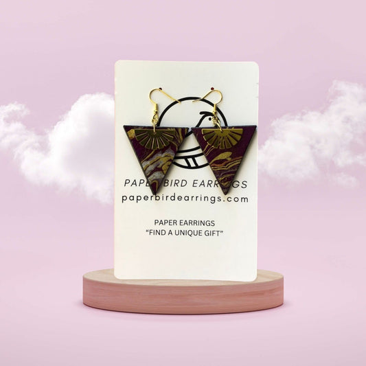 Butterfly-shaped earrings on a display card with a pink background