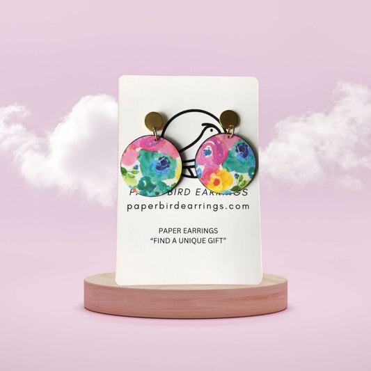 Colorful paper earrings on a white card with 'paperbirdearrings.com' text, against a light pink background.