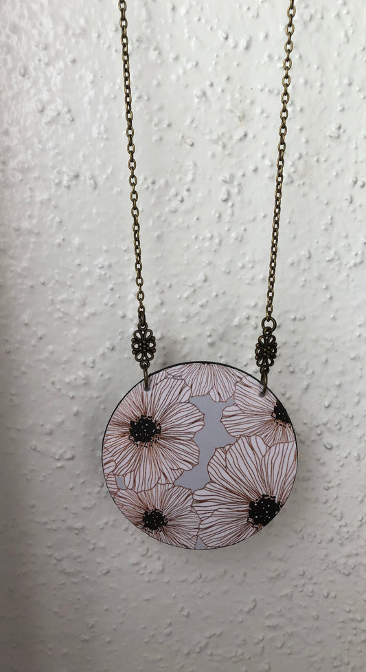Necklace with a circular pendant featuring floral white and gray design