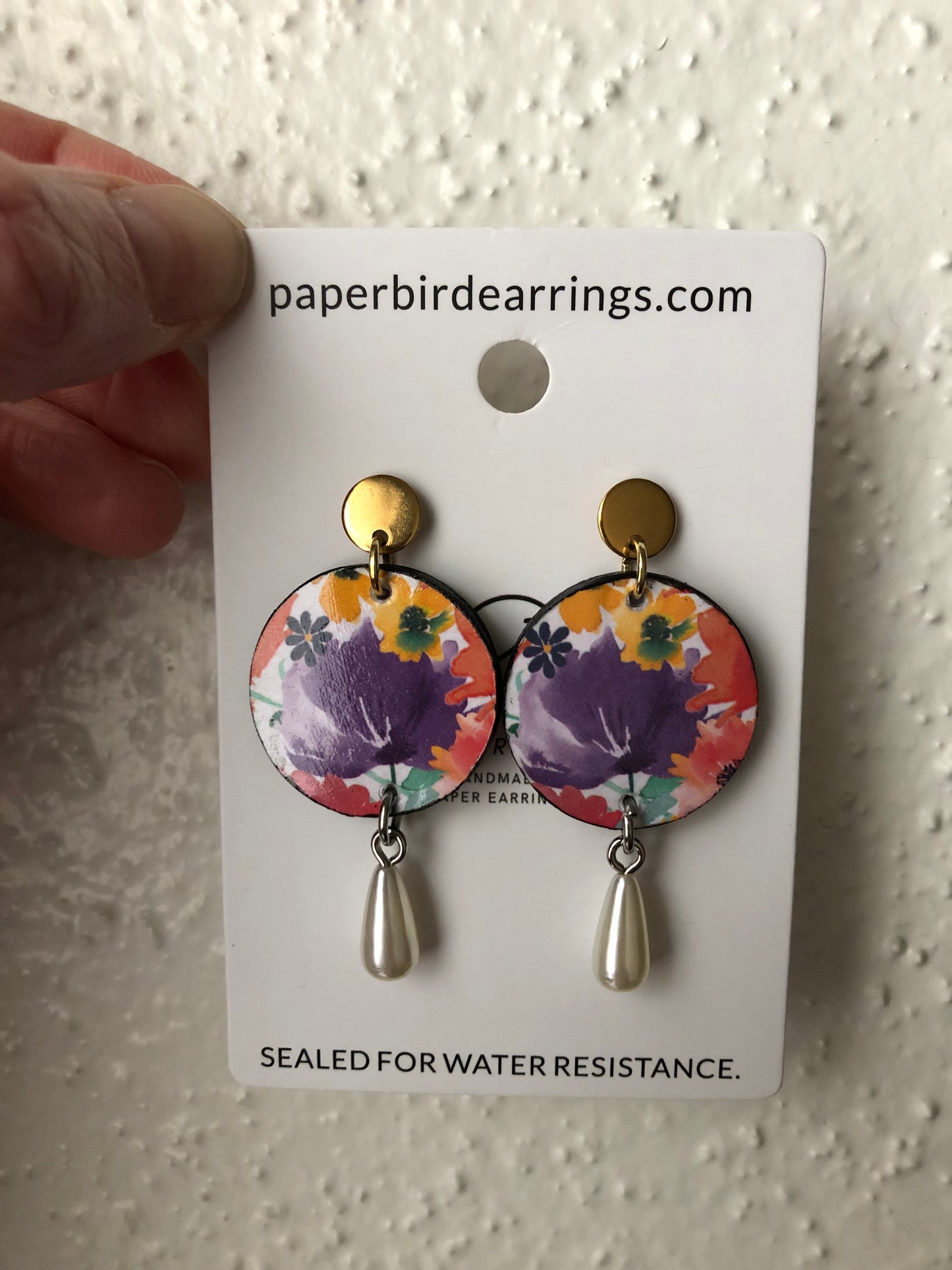 small round paper earrings with a purple flower and pearls