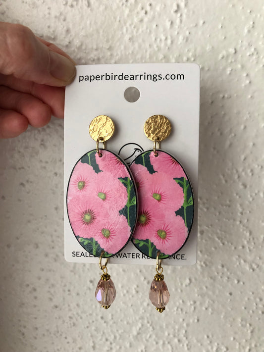 handmade paper earrings with a floral pink design on oval shape